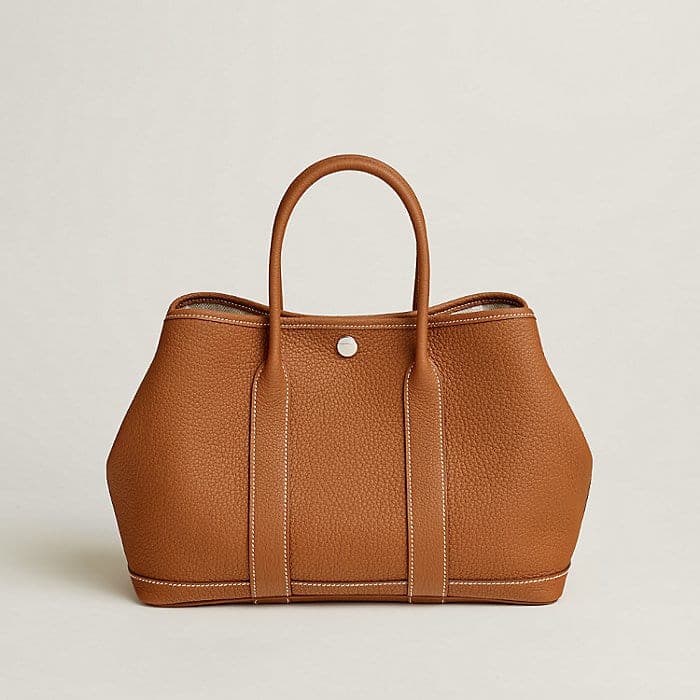 Gold-toned structured Hermès tote in an editorial studio image